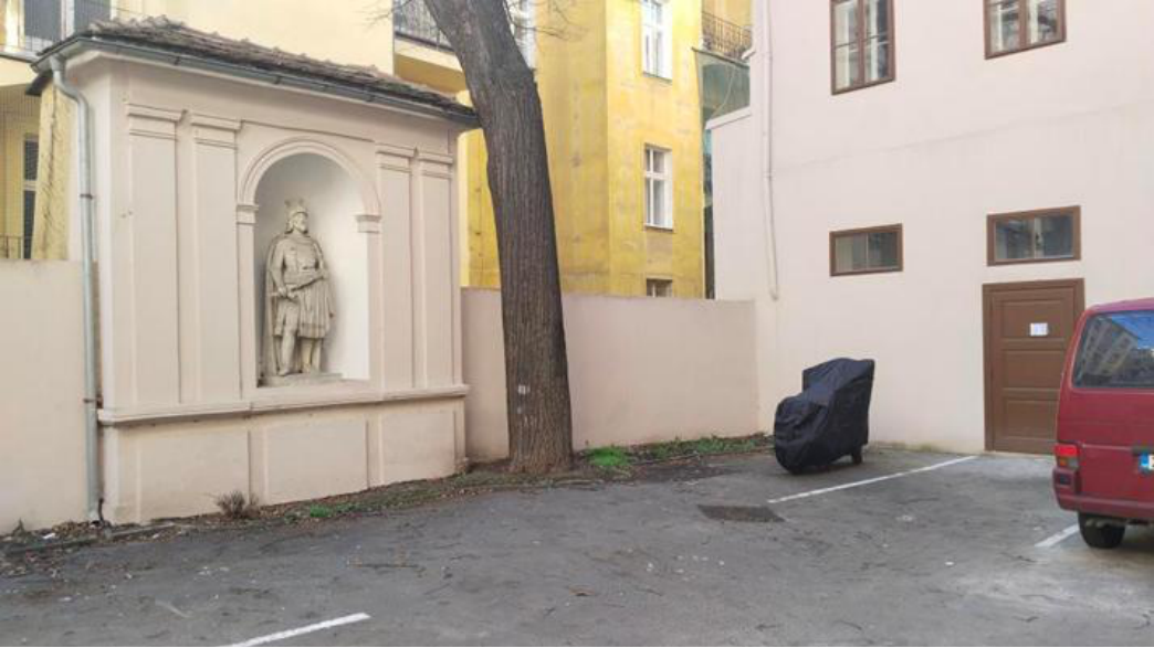 Fotografie exteriéru budovy s výklenkem a sochou v rámci stavebního nebo správního řízení.