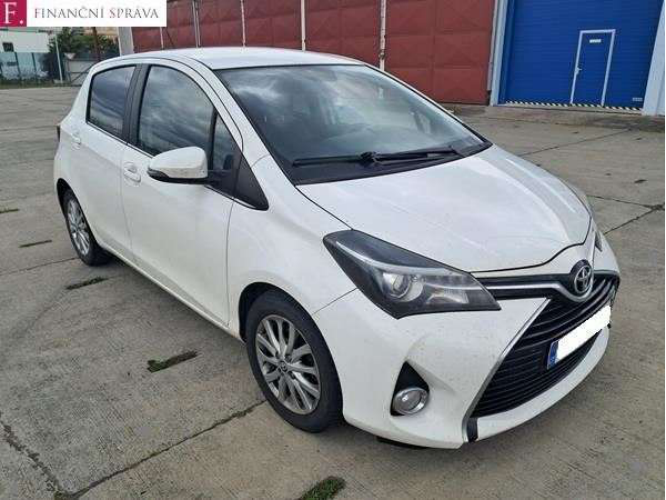 Fotografie bílého osobního automobilu značky Toyota (model Yaris), v levém horním rohu je logo Finanční správy České republiky.