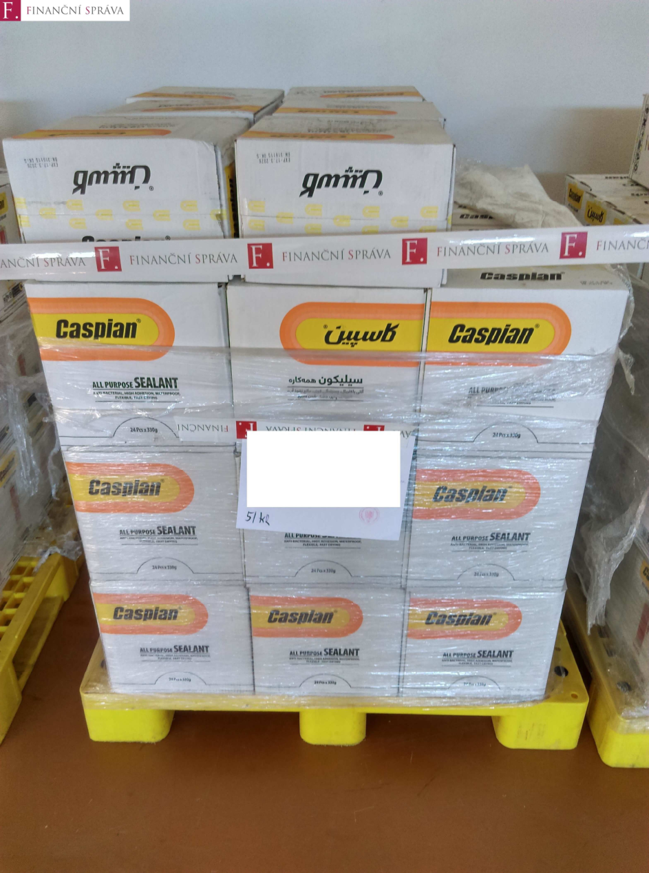 Fotografie palety se zbožím (tmel/sealant značky Caspian). Na krabicích je uvedeno: 'Caspian', 'ALL PURPOSE SEALANT', '24 Pcs x 330g'. Na papírovém štítku uprostřed je ručně napsaná cena '51 Kč'. V horní části obrázku je logo a nápis 'FINANČNÍ SPRÁVA'.