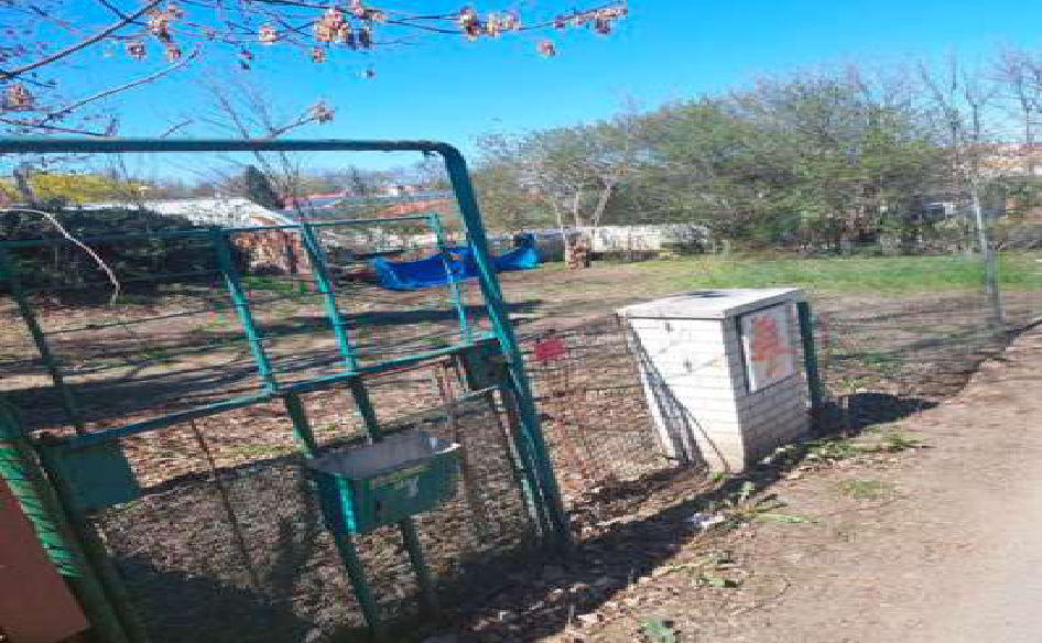 Fotografie pozemku s oplocením a zděným pilířem, pravděpodobně dokumentující stav území v rámci stavebního nebo územního řízení.