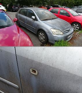 Fotografie šedého osobního automobilu značky Toyota Corolla v zanedbaném a špinavém stavu, stojícího na parkovišti. Na spodním detailním snímku je vidět chyběj…