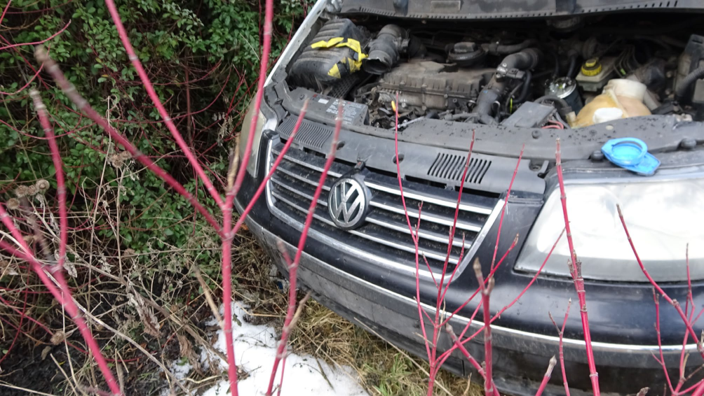 Fotografie opuštěného vozidla na pozemku, pravděpodobně jako součást dokumentace stavu nemovitosti nebo odstraňování autovraků.
