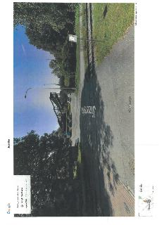 Fotografie z Google Street View (srpen 2024) zachycující ulici Jizerská v Praze, městská část Čakovice. Na snímku je vidět silnice, železniční trať a lávka pro…