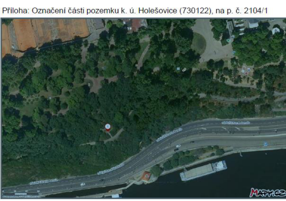 Ortofoto mapa s vyznačením části pozemku. Text v záhlaví: 'Příloha: Označení části pozemku k. ú. Holešovice (730122), na p. č. 2104/1'. V mapě jsou čitelné názvy ulic: 'nábřeží Edvarda Beneše'. V pravém dolním rohu je logo 'MAPY.CZ'.
