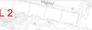 Výřez situačního plánu nebo katastrální mapy s označením 'NN4987' a červeným textem 'L 2'. Zobrazeny jsou půdorysy budov, okolní zeleň a technické značky (kruž…