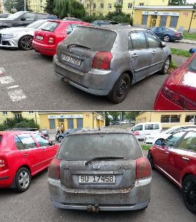 Fotografie extrémně špinavého osobního automobilu značky Toyota Corolla v šedé barvě, registrační značka (SPZ): SU 17458, stojícího na parkovišti před žlutou b…