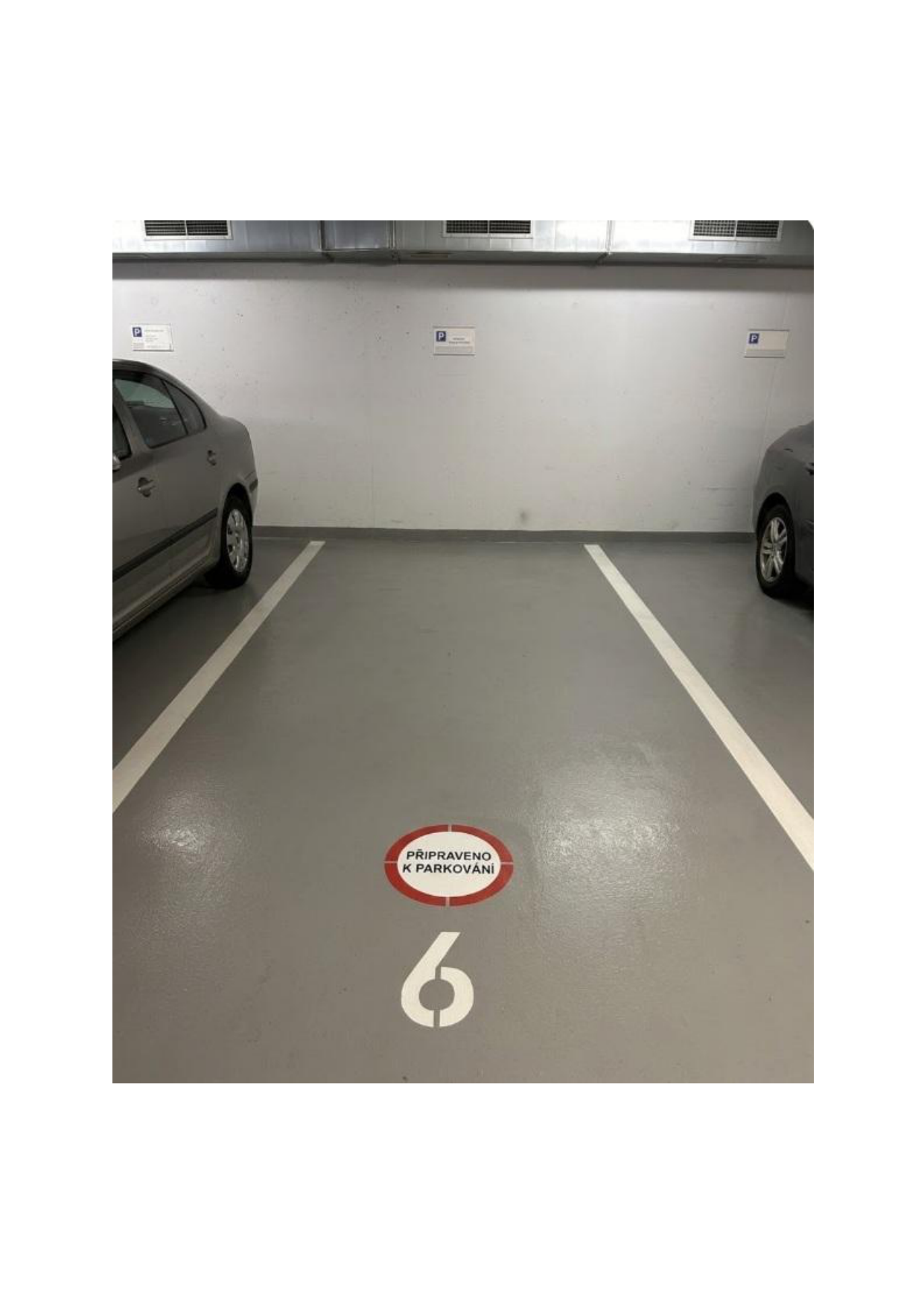 Fotografie parkovacího stání v podzemních garážích, pravděpodobně součást dokumentace k projektu nebo užívání stavby.
