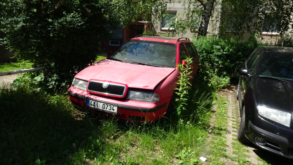 Fotografie zaparkovaného červeného osobního automobilu značky Škoda (pravděpodobně model Octavia Combi) s českou registrační značkou 4A1 0734.