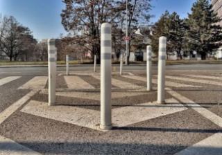 Fotografie veřejného prostranství s dopravními sloupky, pravděpodobně dokumentující stávající stav území.