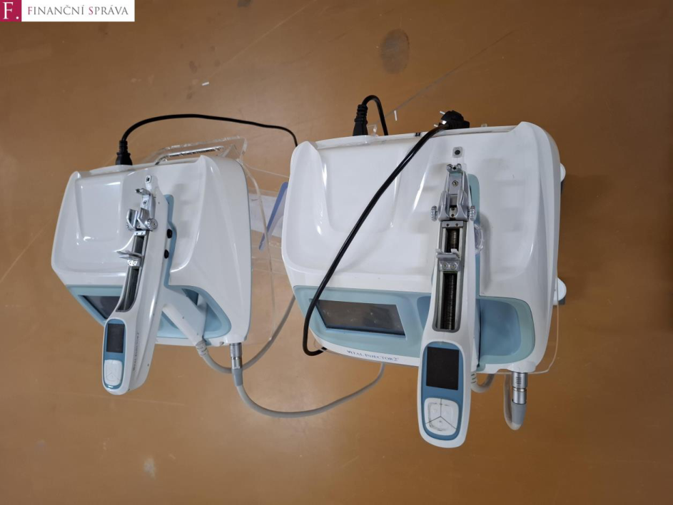 Fotografie dvou kosmetických přístrojů typu 'VITAL INJECTOR 2'. V levém horním rohu je logo 'F. FINANČNÍ SPRÁVA'.