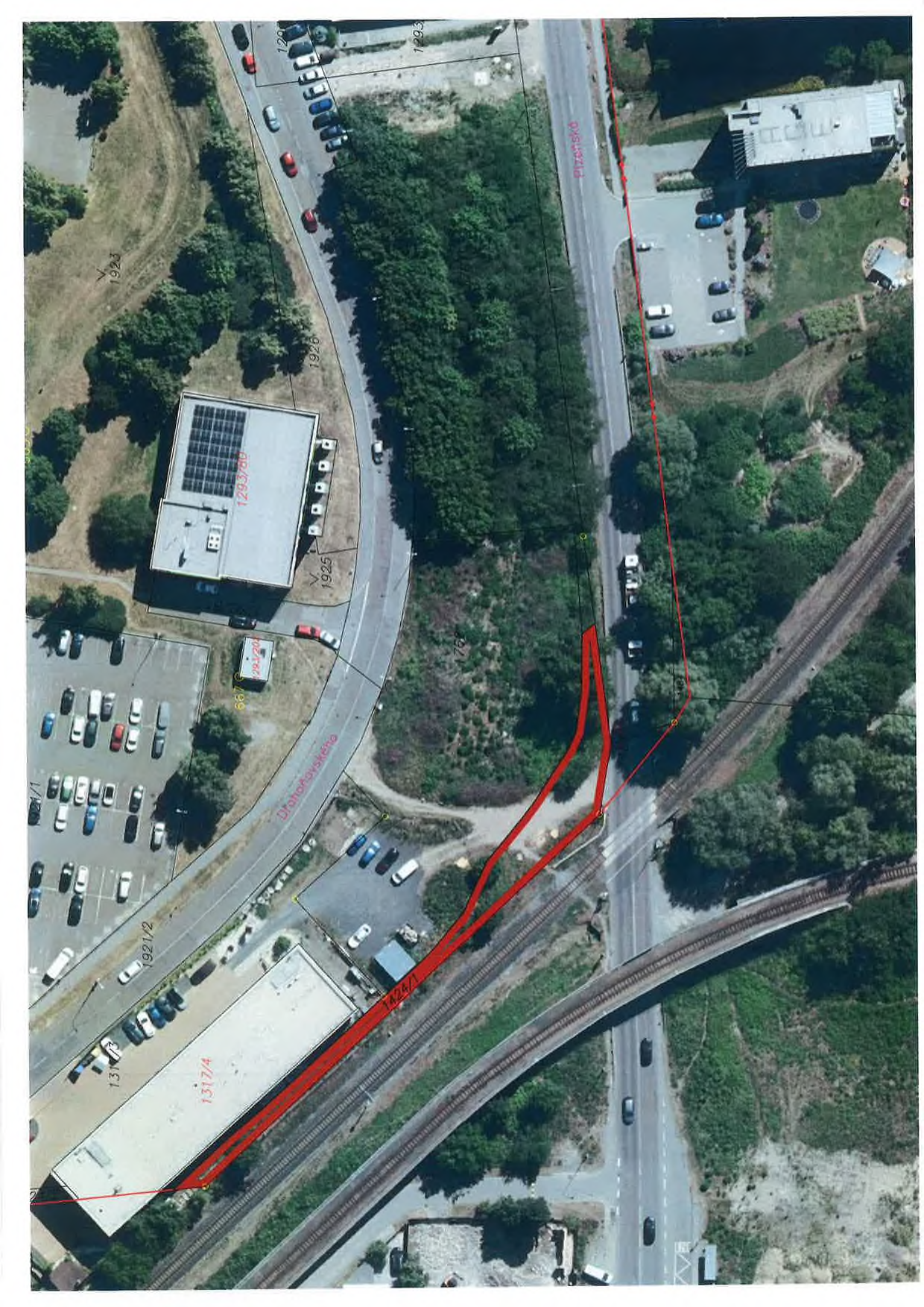 Ortofotomapa území s vyznačeným červeným polygonem (pravděpodobně zábor nebo plánovaná stavba). V mapě jsou čitelné názvy ulic: 'Plzeňská' a 'Drahoňovského'. Dále jsou v mapě vyznačena čísla parcel: '1923', '1293/780', '1925', '1926', '1317/4', '1424/1', '1921/2'.