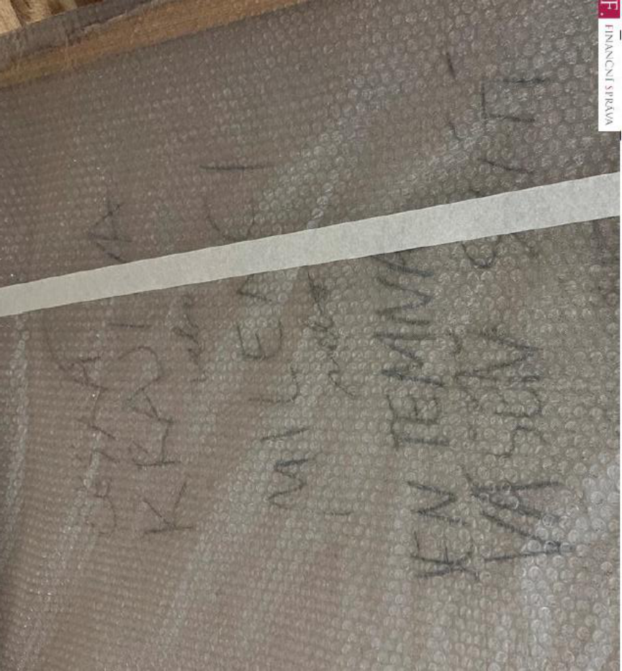 Ručně psaný text na obalovém materiálu (bublinkové fólii): „JEN TEMNÁ VÁŠNIVÁ MILENKA KRÁSNÁ“