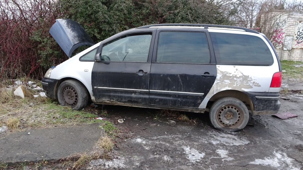 Fotografie opuštěného vozidla na pozemku, pravděpodobně v rámci dokumentace stavu nemovitosti nebo řešení černých skládek.