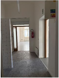 Fotografie interiéru budovy (chodba). Na zdi vpravo nahoře je umístěna bezpečnostní tabulka s texty: 'HLAVNÍ VYPÍNAČ', 'VYPNI V NEBEZPEČÍ', 'POZOR ELEKTRICKÉ Z…
