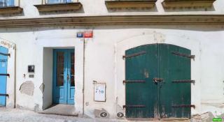 Fotografie budovy s adresním označením a orientačním číslem 357 / 10, s modrými vstupními dveřmi a velkými zelenými dřevěnými vraty.