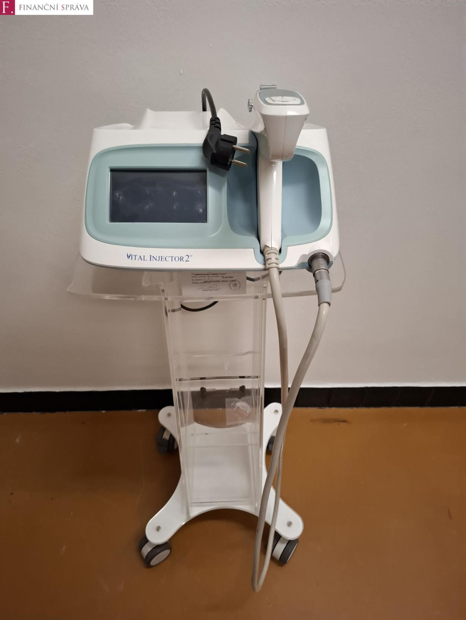 Fotografie kosmetického přístroje 'VITAL INJECTOR 2' na pojízdném stojanu. V levém horním rohu je logo 'F. FINANČNÍ SPRÁVA'.