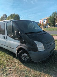 Fotografie poškozené (ohořelé) dodávky Ford Transit parkující na trávě