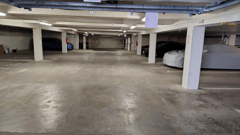 Fotografie interiéru podzemního parkoviště v rámci stavebního objektu.