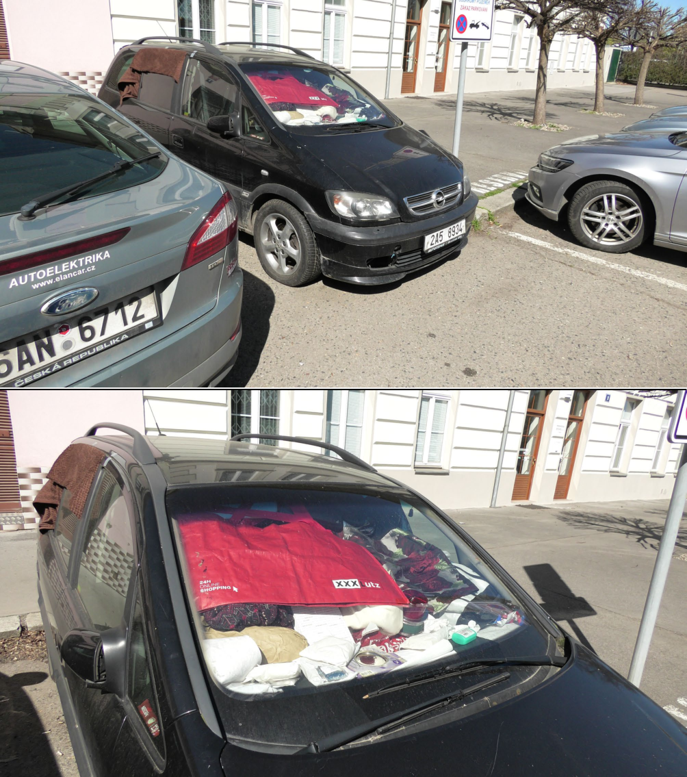 Fotografie zaparkovaných vozidel na ulici. Na stříbrném voze vlevo je nápis 'AUTOELEKTRIKA www.elancar.cz' a registrační značka '5AN 6712'. Černý vůz uprostřed má registrační značku '2A5 8934' a za čelním sklem je umístěna červená nákupní taška s logem 'XXX Lutz' a nápisem '24H ONLINE SHOPPING'. V pozadí je dopravní značka zákaz zastavení.