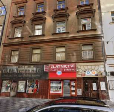 Fotografie uliční fasády bytového domu se sídlem provozovny (zlatnictví) v přízemí.